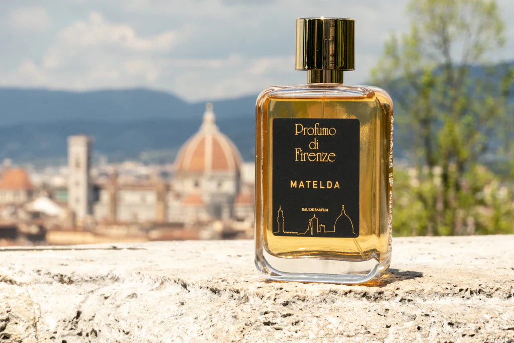 La boccetta del profumo Matelda di Profumo di Firenze con Firenze che fa da sfondo - fragranze artistiche e creme corpo coordinate da Amarsi Beauty Jesolo